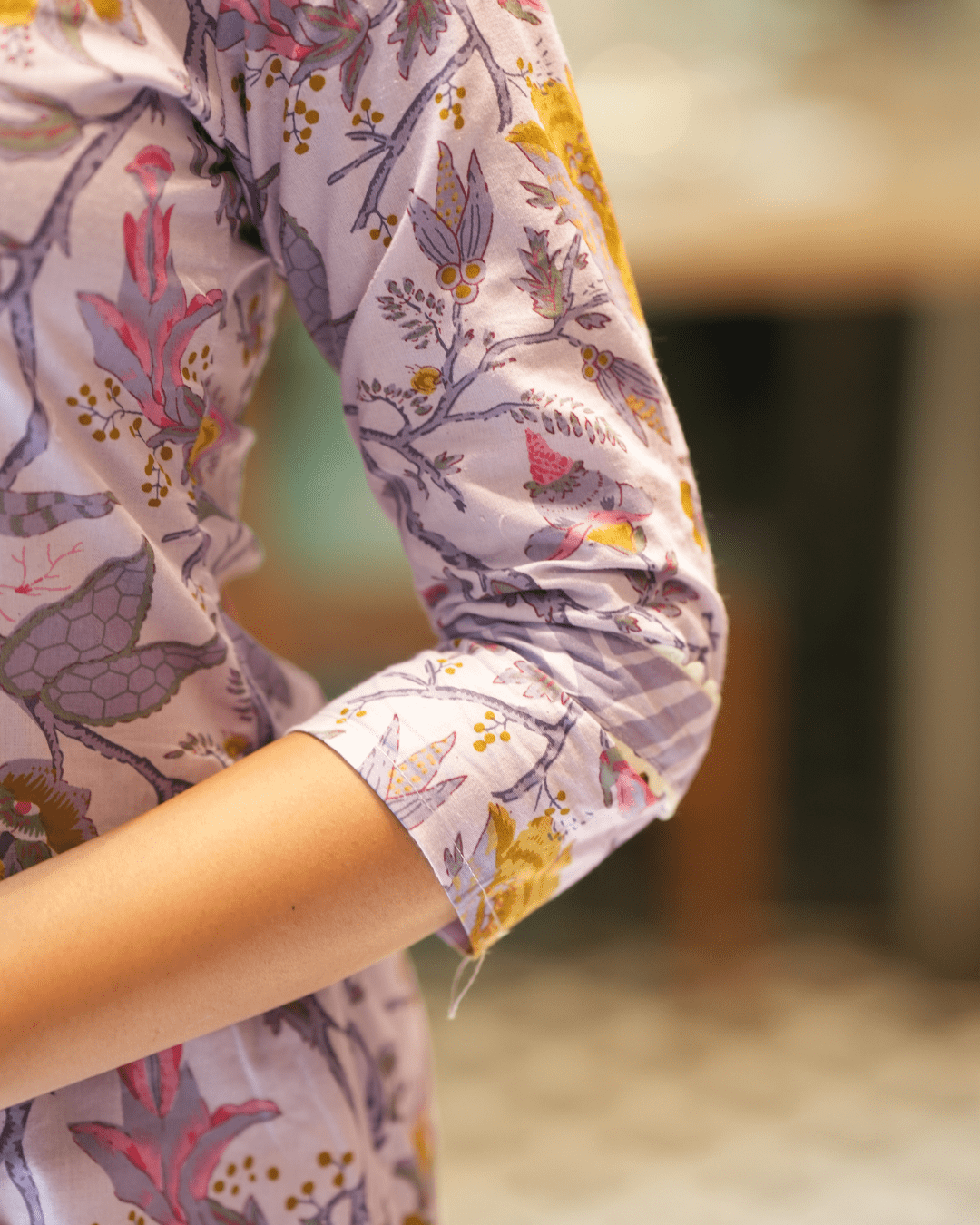 Elegant cotton kurta with floral print, V-neckline, and three-quarter sleeves, perfect for festive and casual wear.