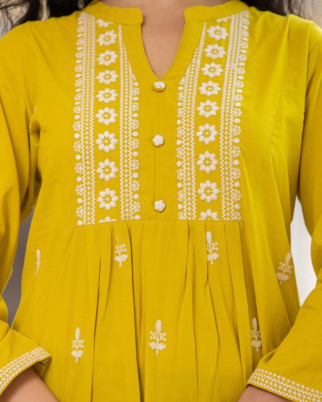 Detailed Chikankari embroidery on yellow cotton short kurti, designed with a modern collar neck and buttons, available at Layas Marts