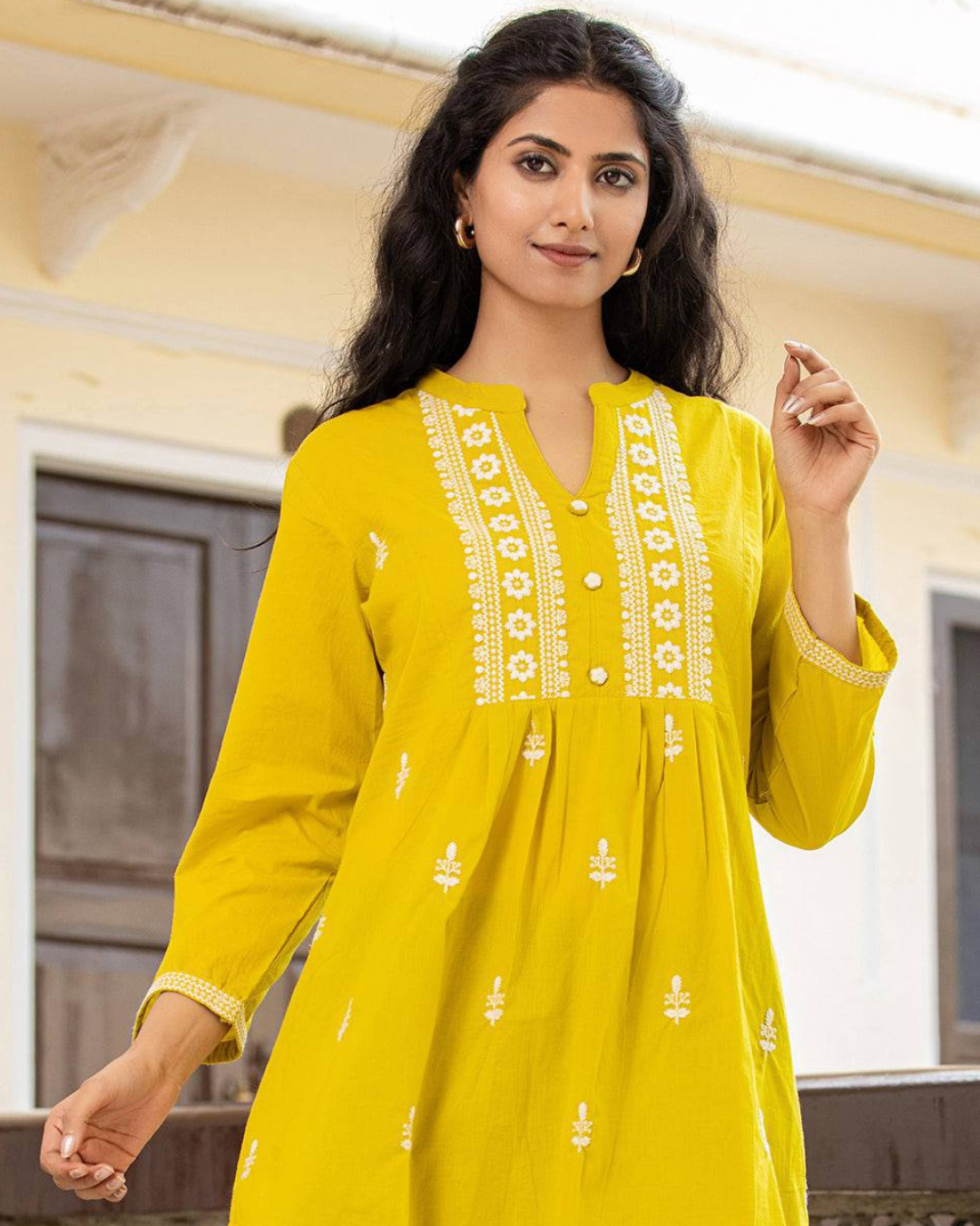 Detailed Chikankari embroidery on yellow cotton short kurti, designed with a modern collar neck and buttons, available at Layas Marts